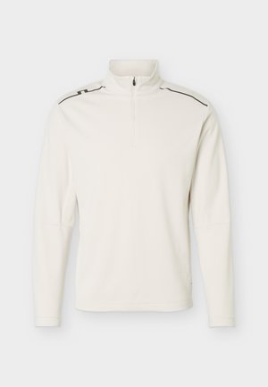 Sudadera de manga larga color blanco roto con cremallera de cuarto y detalles de líneas negras en las costuras de los hombros, mostrada sobre un fondo claro y liso.