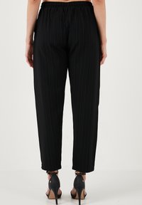 LELA SLIM FIT - Hlače - black