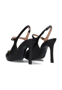 Scarpe nere in pelle con tacco alto, design peep-toe, fascia slingback e dettaglio in metallo dorato. Texture liscia con finitura lucida.