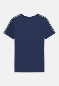 T-shirt bleu marine à manches courtes avec un col rond et des détails en rayures blanches contrastantes sur les épaules et les manches. Texture lisse.