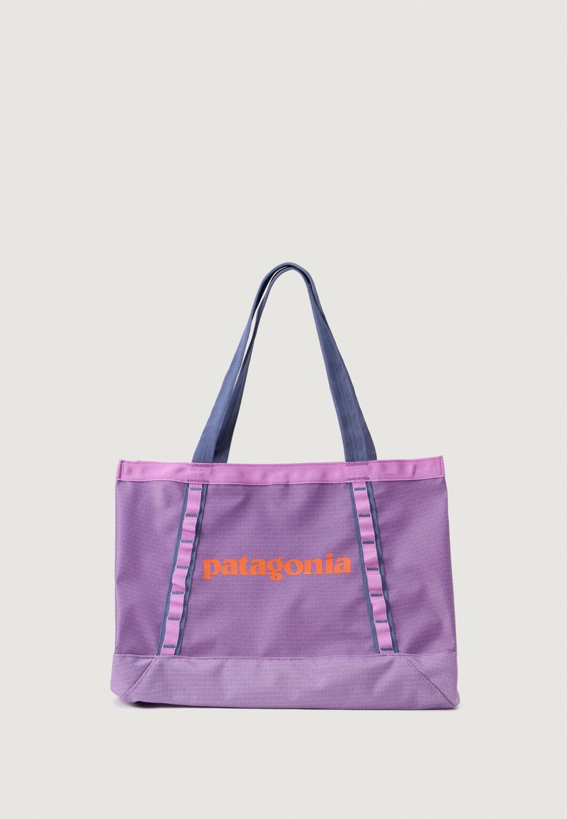 Fialová nylónová taška s oranžovým logom "patagonia". Obsahuje kontrastné modré uši a vertikálne akcenty po stranách.