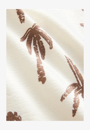 Austa medžiaga su reljefiniu, raukšlėtu paviršiumi, kuriame dominuoja kreminė fonas ir rudi palmės lapų raštai.