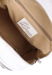 Interno di una borsa in pelle bianca con una fodera in tessuto beige liscia. Presenta una tasca con zip e un'etichetta con la scritta "Made in Italy" in testo embossato.
