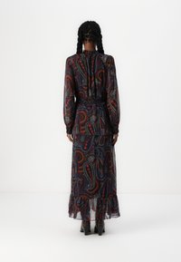 Vestido longo e fluido em tecido transparente com estampa de paisley em vermelho, azul e creme. Apresenta uma bainha com pregas e mangas longas com punhos elásticos.