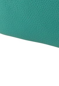 Turkoois gestructureerd leer met een korrelige afwerking, gebogen vorm en gladde randen. Geen zichtbare hardware of accenten.
