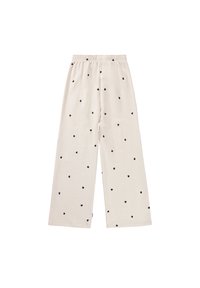 Pantalones de pierna ancha color crema con un patrón de corazones negros, cinturilla elástica y textura de tejido suave.