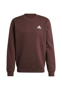 Brun sweatshirt i mjukt tyg med rund halsringning, långa ärmar och en vit Adidas-logotyp på övre vänstra bröstet.