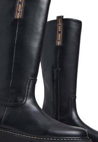 Stivali neri in pelle fino al ginocchio con una texture liscia, dotati di una zip laterale e una cucitura bianca a contrasto sulla suola.