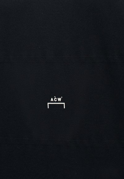 Μαύρο ύφασμα με μικρό λευκό λογότυπο "A C W*" πάνω από ένα λευκό ορθογώνιο περίγραμμα, οριζόντια κεντραρισμένο.