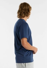 Camiseta de manga corta azul marino con cuello redondo, hecha de algodón suave, presenta un corte relajado y una textura lisa.