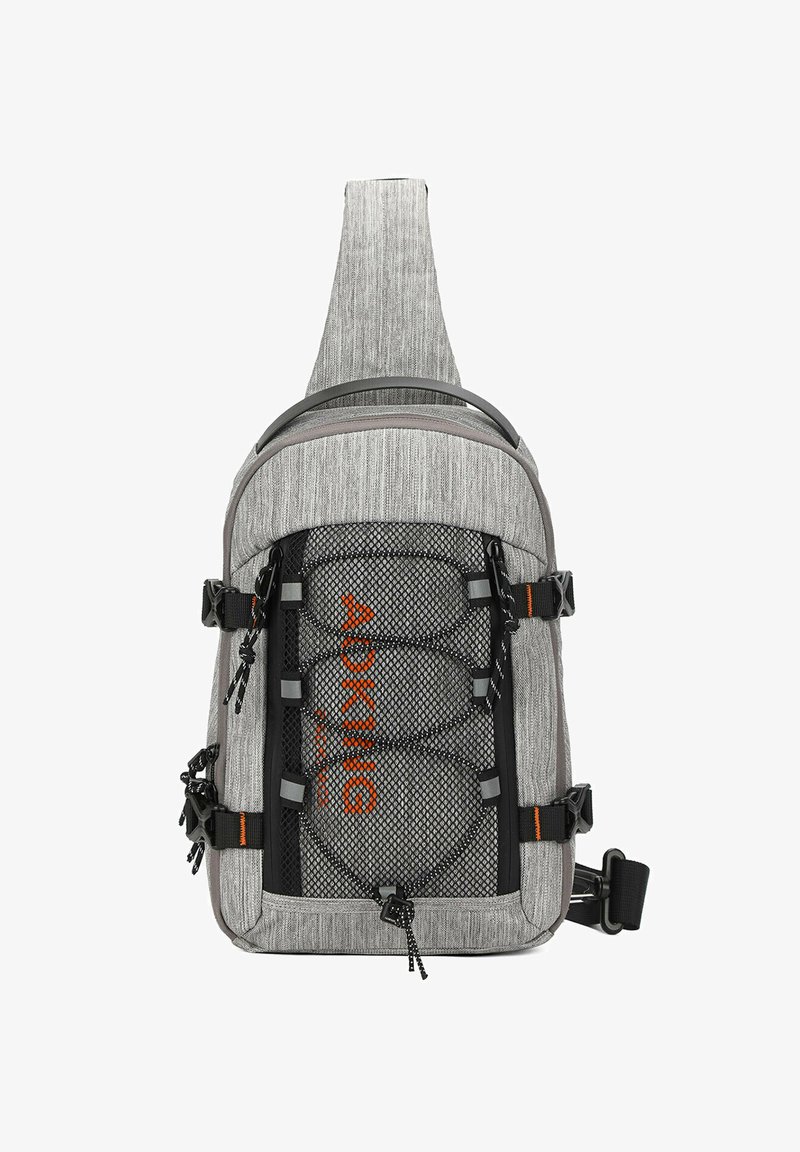 Sac à bandoulière en tissu gris avec des panneaux en maille, des accents noirs et des lettres orange. Il dispose de bretelles ajustables et de plusieurs points de fixation.