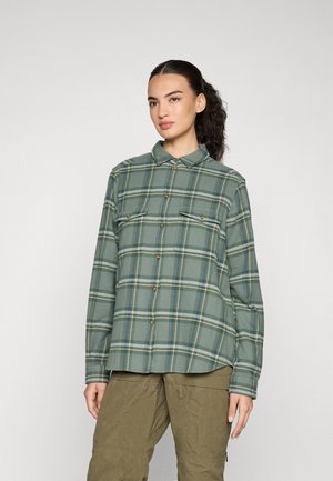 Groene geruite flanellen blouse met knoopsluiting, lange mouwen en twee borstzakken. Bevat gele en blauwe strepen in het patroon.