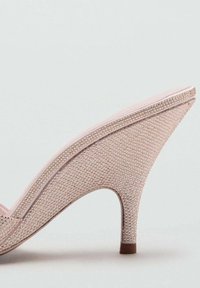 Chaussure à talon rose avec une tige texturée recouverte de petits éléments brillants. Dotée d'un bout pointu et d'un talon fin de hauteur intermédiaire.