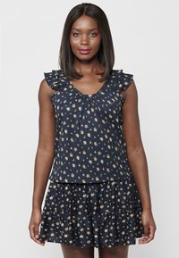 Abito floreale navy con gonna a strati e volant. Presenta maniche corte con volant e scollatura arricciata, decorata con piccoli fiori gialli e bianchi.