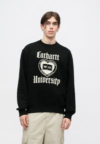 Czarny sweter z dużą, kremową grafiką z napisem "Carhartt University" oraz "WIP 313". Rękawy i pas ribbed. Miękka tkanina.