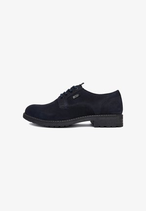 Donkerblauwe suède veterschoenen met een afgeronde neus en een gerubberde, gestructureerde zool; voorzien van een klein logoplaatje en contrasterende stiksels op het bovenwerk.