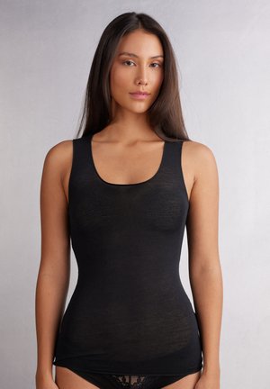 Top noir sans manches avec un décolleté arrondi, fabriqué en matériau lisse, présentant une silhouette ajustée et un léger détail de texture.