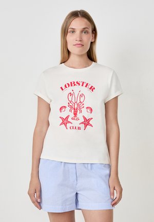 T-shirt crème à manches courtes avec un motif de homard rouge et d'étoile de mer, associé à un short rayé bleu clair et blanc.