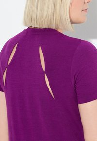 Fialový krátký rukáv top s detaily výřezů na zádech. Měkká textura s přiléhavým střihem a hladkým výstřihem.