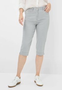 Pantaloni cropped grigio chiaro con design aderente, dotati di chiusura con bottone frontale e tasche laterali. Realizzati in un morbido tessuto elasticizzato.