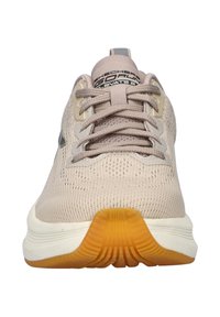 Scarpe atletiche beige con tomaia in mesh, superficie testurizzata e punta rotonda. Lacci regolabili e suola in gomma con accenti arancioni.