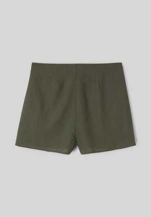 Short taille haute pour femme vert olive avec un devant lisse et un ourlet droit sur un fond gris clair.