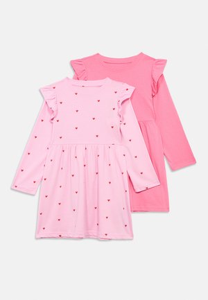 Deux robes roses à manches longues pour tout-petit avec des détails à volants sur les épaules ; une rose unie, l'autre rose clair avec de petits imprimés de cœurs rouges.