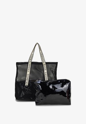 Zwarte mesh draagtas met witte handvatten, gelabeld met "FASHION BAGS", gecombineerd met een kleinere glanzende zwarte ritszak.