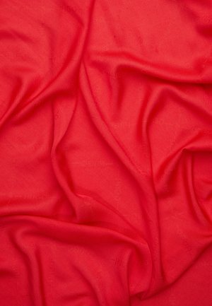 Tissu rouge vif avec des plis visibles et des plis doux créant une surface texturée.