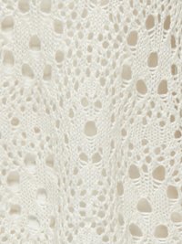 Tissu en dentelle tricoté en blanc, avec un motif ajouré comportant de petits trous et des designs délicats en un fil texturé doux.