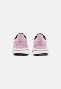 Zapatillas de correr Adidas con una parte superior de malla principalmente rosa, acentos negros, entresuela Boost blanca y detalles texturizados en el talón.