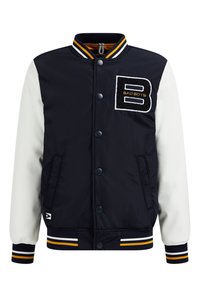 Svart och vit collegejacka med framtill knappar, randiga ärmslut och krage, samt en stor "B"-applikation märkt "BAD BOYS" på bröstet.