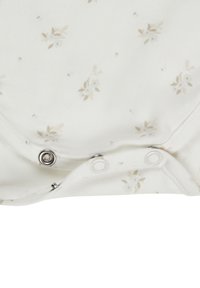 White cotton bodysuit with small beige floral pattern, features snap buttons at the bottom for easy dressing. Soft texture, rounded neckline.