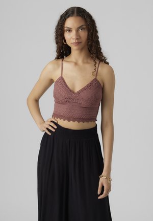 Háčkovaný crop top v barvě starorůžové s výstřihem do V, tenkými nastavitelnými ramínky a krajevým lemem; spárován s černou skládací sukní.