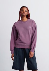 Purple cotton sweatshirt with a round neckline and ribbed cuffs, paired with black knee-length shorts, featuring a small logo on the chest.