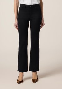 Zwarte flared jeans van denim met een gladde textuur. Voorzien van een knoop aan de voorkant, riemlussen en zijzakken. Draagt met gemusterde hakken.