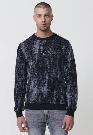 Suéter de punto en azul marino y gris con un patrón texturizado, que presenta un cuello redondo y puños y dobladillo acanalados.