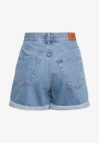 Ljust blå denimshorts med uppvikta fållar, två bakfickor och en läderlapp märkt "BDG" vid midjan.