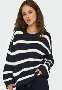 Námořnický a bílý pruhovaný oversized pletený svetr s ribbed kulatým výstřihem a dlouhými rukávy, který má texturovaný vzor.