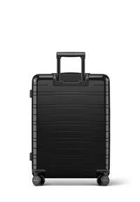 Black hard-shell suitcase with vertical ridges, retractable handle, and four wheels for mobility. Smooth texture with minimal accents.