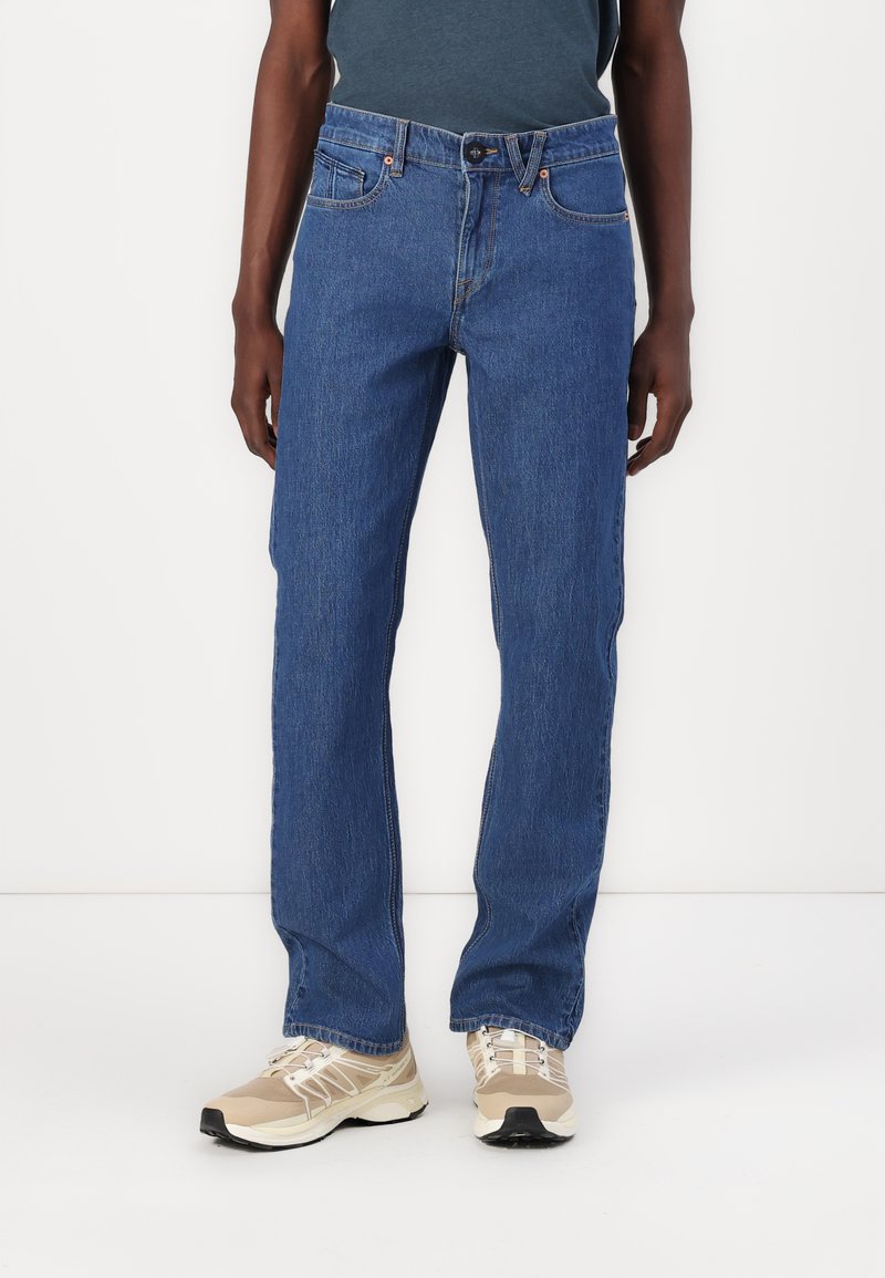 Blue denim jeans with a straight fit. Features include five pockets, a button closure, and stitching accents along the seams.