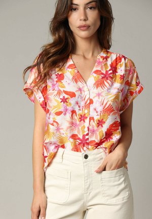 Chemise à manches courtes, boutonnée, avec un motif floral en orange, rose et jaune sur un fond clair, fabriquée à partir d'un tissu léger.