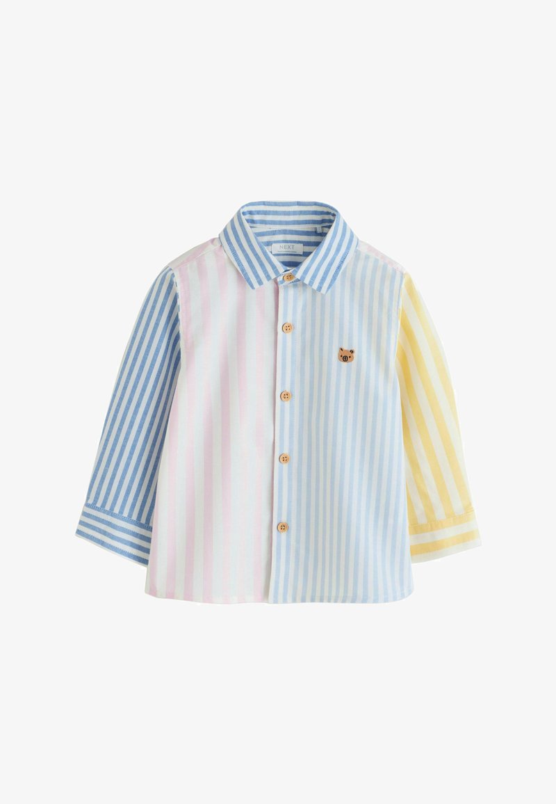 Chemise boutonnée à manches longues avec des rayures verticales en bleu, rose et jaune, ornée d'un petit patch ours sur la poitrine.