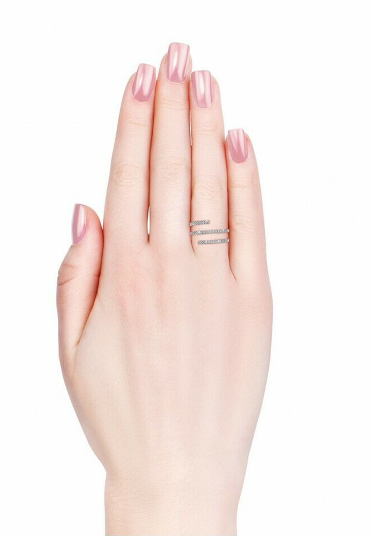 Zilveren ring met drie horizontale banden versierd met kleine doorzichtige edelstenen, gedragen aan een hand met lichtroze gepolijste nagels.