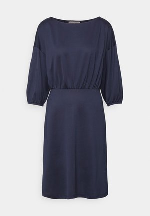 Vestido azul marinho feito de tecido suave, com um corte solto, mangas tipo balão e uma cintura franzida para adicionar forma.