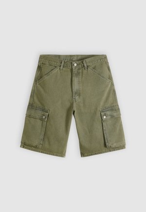 Olive green cargo shorts with diagonal pockets and two side cargo pockets, made from textured cotton fabric with vertical stripes.