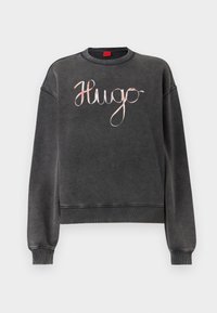 Gray sweatshirt with a relaxed fit, featuring a crew neckline and ribbed cuffs. It has a glossy, cursive "Hugo" logo in pastel colors on the front.