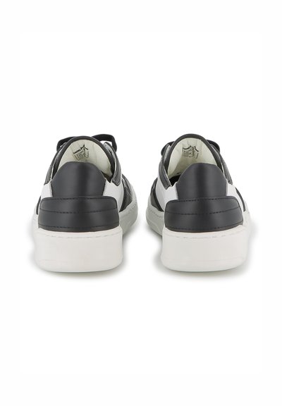 Baskets en cuir noir et blanc avec une texture lisse, une forme arrondie et une semelle en caoutchouc blanc. La vue arrière montre des détails au niveau du talon.
