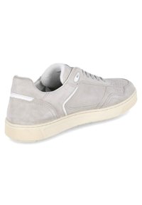 Baskets en suede gris avec un détail de rayure blanche, bout texturé et semelle en caoutchouc. Lacets et œillets visibles, col rembourré pour le confort.