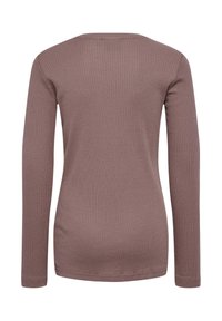 Długi rękaw, prążkowany top w stonowanym kolorze mauve. Posiada okrągły dekolt i dopasowany krój. Gładka tekstura z subtelnym rozciąganiem.